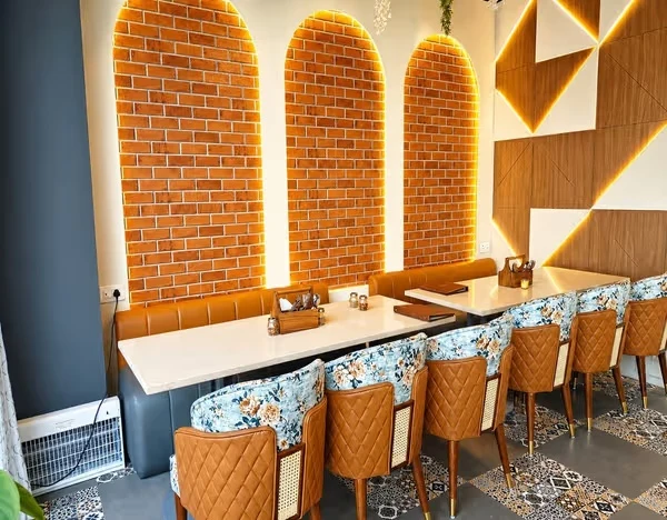 Golden light outlining brick arches and family dining tables